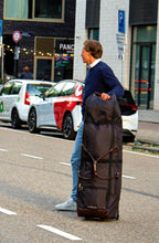 Man standing in the street with the John Martin Golf Travel Bag.